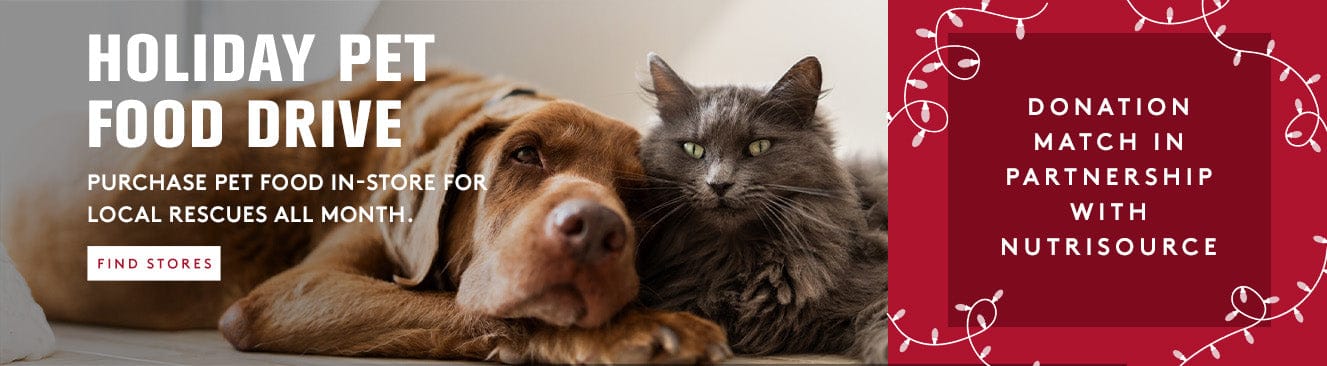 Dog and cat lying together with promotional text for a holiday pet food drive and donation match partnership.